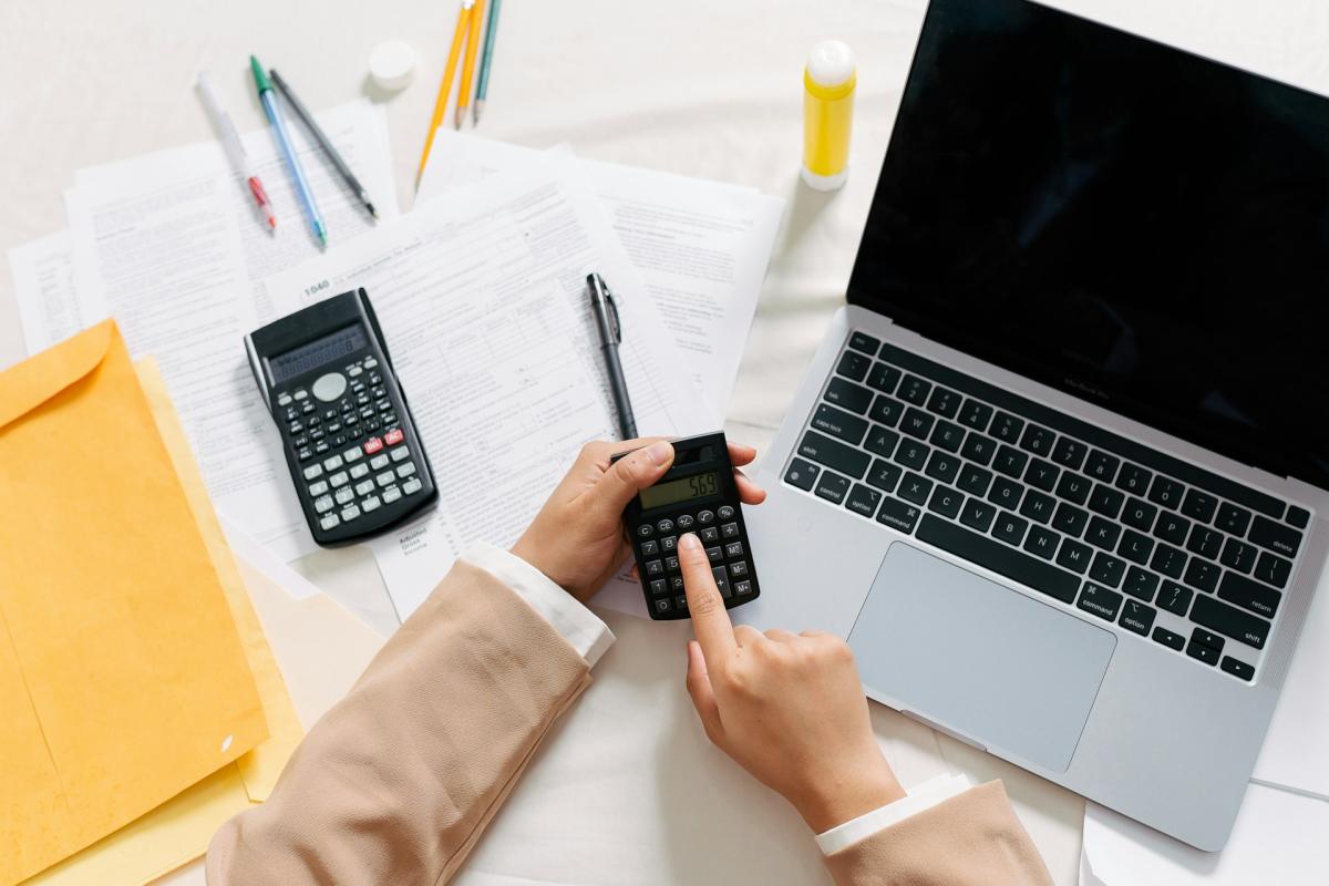 person using laptop and calculator